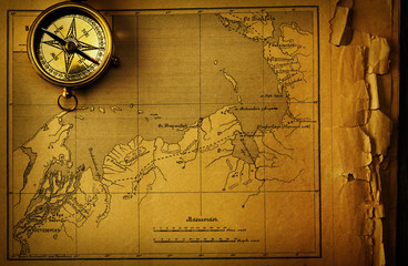 Antique compass over old map