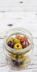 Fototapeta na wymiar Pickled olive in a mason jar over wooden background