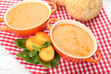 Carrot cream-soup with buns on table close up