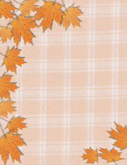 Photo frame of fall autumn maple leaves on an orange plaid background for Halloween Thanksgiving