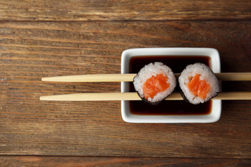 Rolls with sauce and sticks on wooden table close up