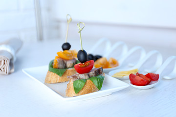 Tasty canapes on wooden table, close up