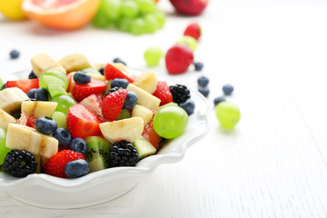 Naklejka na ściany i meble Fresh fruit salad on white wooden table
