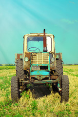 Obraz premium Tractor in field on blue sky background