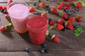 Glasses of berry smoothie on wooden table, closeup