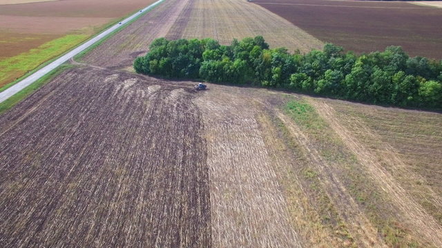 Aerial: Tractor plowing the soil