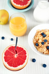Tasty cornflakes with fruits and berries on table close up