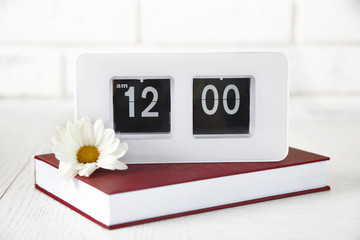 Modern Clock and book, on light wall background