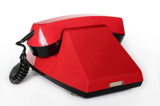 Red retro telephone with no dial isolated on white background