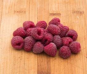 Ripe sweet raspberries on wood table close-up