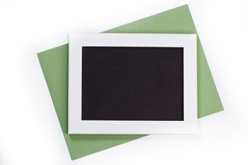 horizontal white photo frame with black field and green paper un