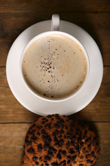 Cup of coffee with cookies on wooden table, top view