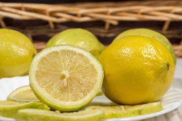 Lemons and slices in front of a wicker basket