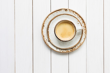 Cup of coffee on white wooden table. Top view 