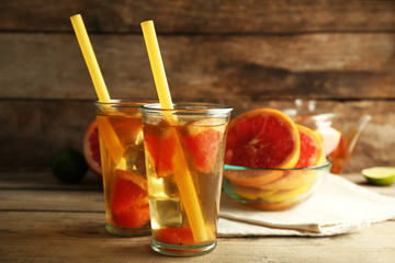 Iced tea with lemon and grapefruit on wooden background
