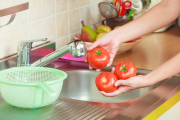 woman washing fresh vegetables in kitchen