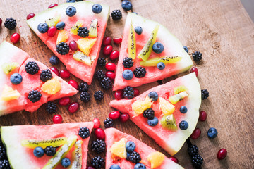 colorful tropical fruit watermelon pizza topped with kiwifruit,