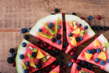 colorful tropical fruit watermelon pizza topped with kiwifruit,