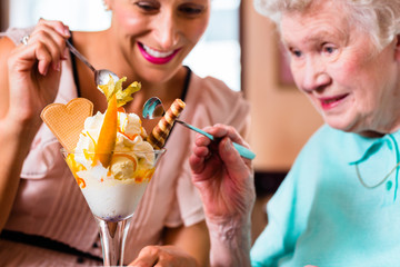 Oma und Enkelin essen Eisbecher im Cafe