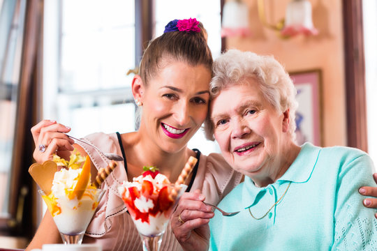 Oma und Enkelin essen Eisbecher im Cafe