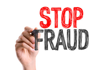 Hand with marker writing: Stop Fraud