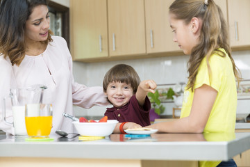 Lovely  Mother and her children having breakfast