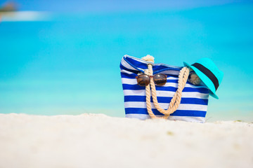 Beach accessories - blue bag, straw hat, sunglasses on white