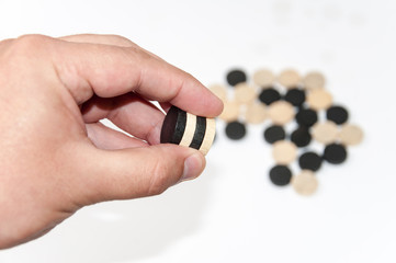 Wooden black and white chips in the hand