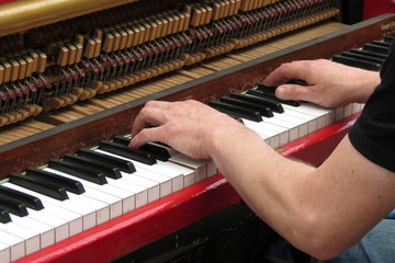 hands playing upright piano © Route66