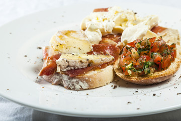 Bruschetta with prosciutto, goat cheese and fried tomatoes