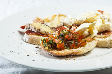 Bruschetta with prosciutto, goat cheese and fried tomatoes