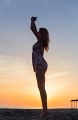 Obraz premium Portrait of beautiful young woman on the beach sunset