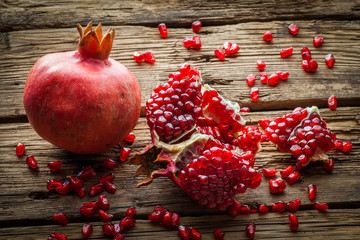 Juicy pomegranate fruit over wooden table