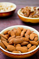 Assorted nuts in dishes on wooden table