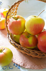 Green and red organic apples in basket