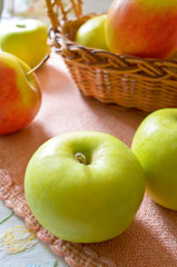 Green and red organic apples in basket