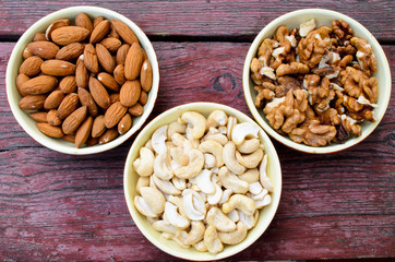 Assorted nuts in dishes on wooden table