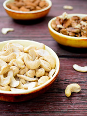 Assorted nuts in dishes on wooden table