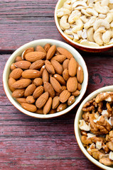 Assorted nuts in dishes on wooden table