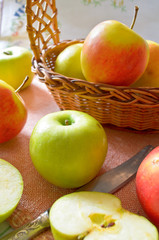 Green and red organic apples in basket