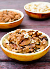 Assorted nuts in dishes on wooden table