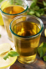 Glasses of apple juice on wooden table, closeup