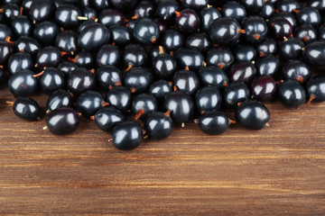 Heap of wild black currant on wooden table close up