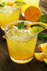 Glasses of lemon juice on wooden table, closeup