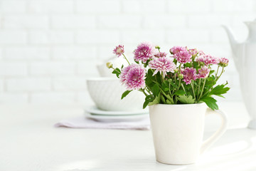 Obraz na płótnie Canvas Beautiful flowers in decorative vase on table, on light background