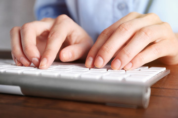 Female hands typing on keyboard close up