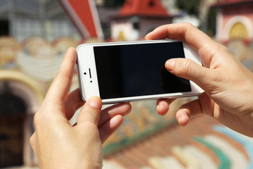Female hands holding smart mobile phone outdoors