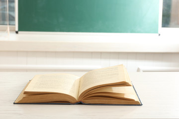 Women hands with book on blackboard background