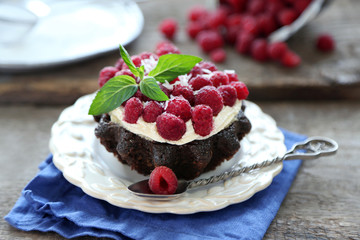 Sweet cakes with raspberries on wooden table background