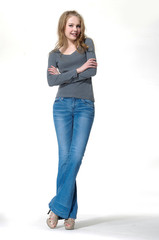 Portrait of young woman in jeans standing full-length